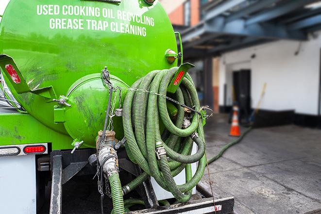 a technician pumping a grease trap in a commercial building in Rossford, OH